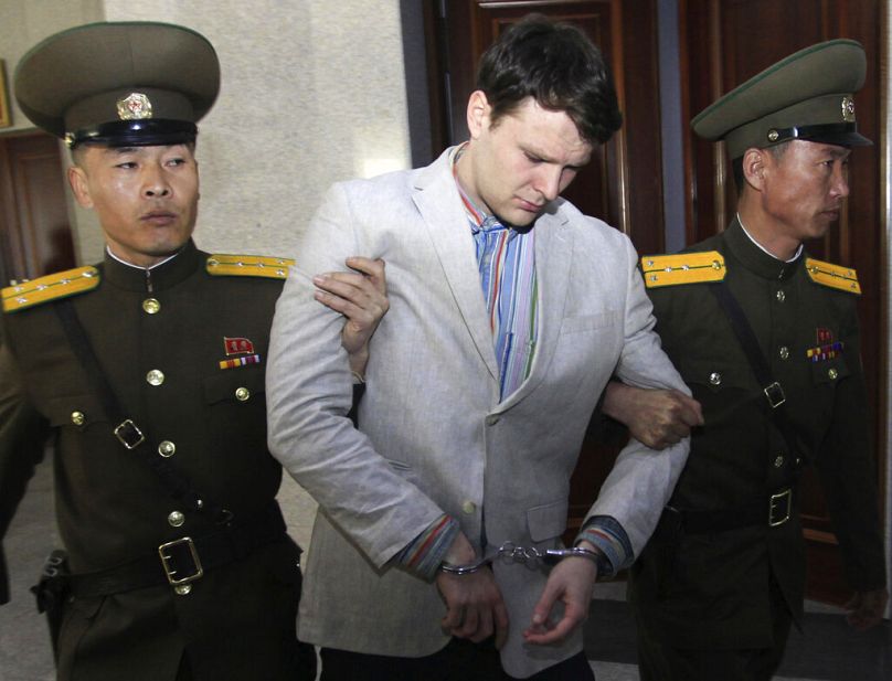 Otto Warmbier eskortowany przez funkcjonariuszy Sądu Najwyższego Korei Północnej, marzec 2016 rok