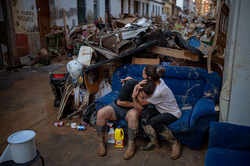 Tania abraza a su cuñado Baruc tras rescatar algunas de sus pertenencias de su casa inundada tras las inundaciones en Paiporta, Valencia, España, el 5 de noviembre de 2024