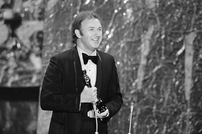 Gene Hackman sorri enquanto segura o Óscar que acabou de receber como “melhor ator” de 1971 pelo seu papel em “The French Connection”