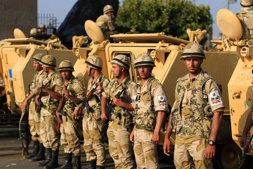 صورة من الأرشيف- جنود من الجيش المصري يتخذون مواقعهم بالقرب من المدرعات لحراسة مداخل ميدان التحرير، في القاهرة، مصر، الاثنين 8 يوليو 2013