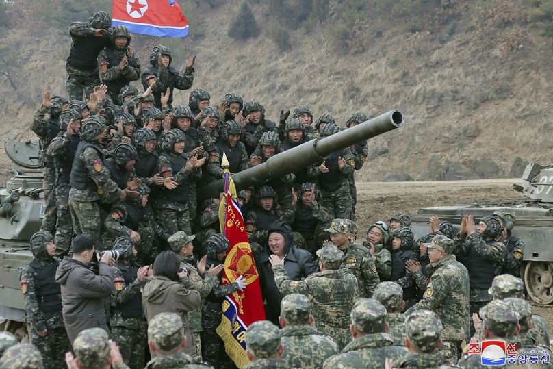 FILE - In this photo provided by the North Korean government, North Korean leader Kim Jong Un, center, meets soldiers who took part in a training in North Korea, on March 13, 