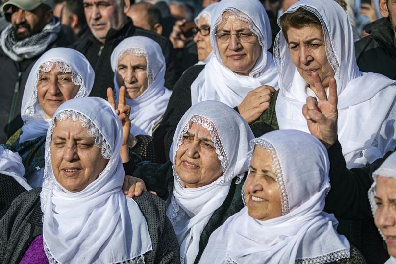 Des femmes kurdes regardent les membres d'une délégation du DEM, publier une déclaration du chef emprisonné du PKK, Abdullah Öcalan, à Diyarbakir, en Turquie, le 27.02.25