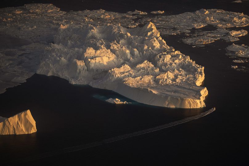 Statek płynie obok dużego lodowca w Ilulissat, Grenlandia.