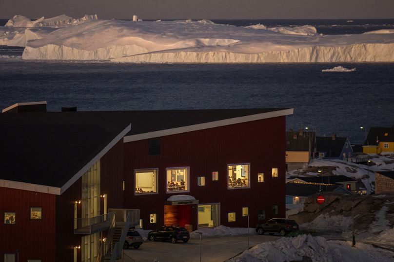 Uczniowie szkół publicznych są widoczni w swoich klasach, a w tle widać duże lodowce w mieście Ilulissat, Grenlandia.