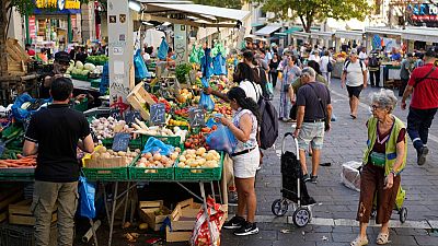 People shop at a street grocery market in Marseille, France, Thursday, Sept. 14, 2023.