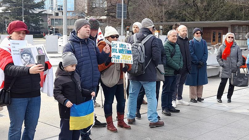 Участники манифестации "России Будущего" на площади Наций в Женеве с плакатами: "Старики украли у молодёжи будущее" и "Моя страна превратилась в ГУЛАГ", 1 марта 2025 г.