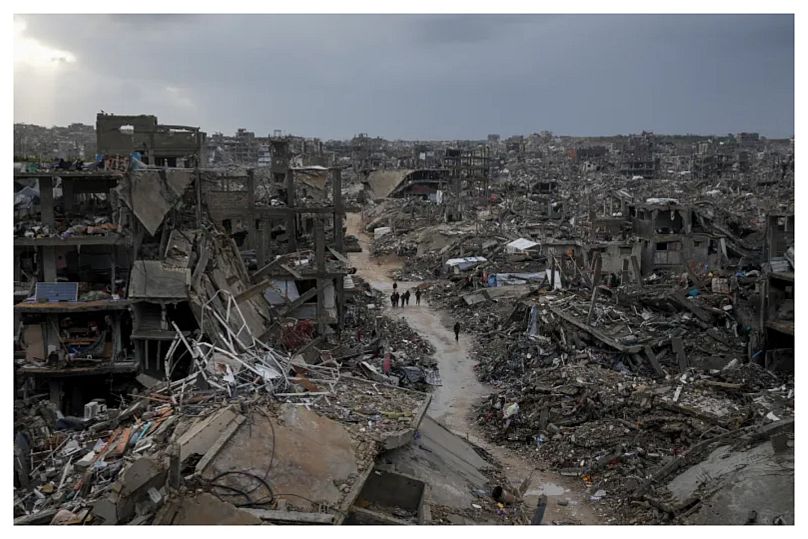 فلسطينيون يسيرون وسط الدمار الذي خلفه الهجوم الإسرائيلي الجوي والبري في جباليا، قطاع غزة، الخميس 6 فبراير 2025.