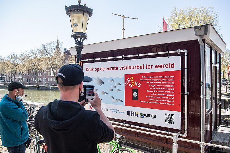 Signs posted near the Weerdsluis in Utrecht explain the purpose of the Fish Doorbell.