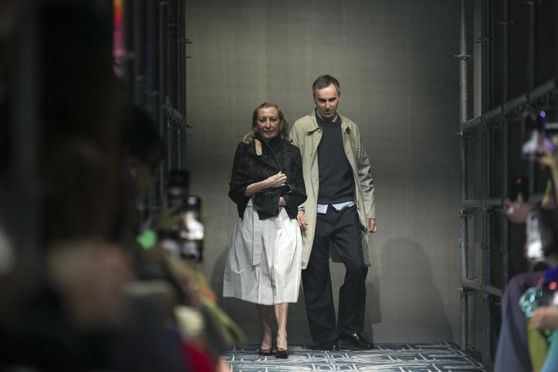 I direttori creativi Miuccia Prada e Raf Simons ricevono gli applausi dopo la presentazione della collezione Prada Autunno/Inverno 2025-2026, Milano, 27 febbraio 2025