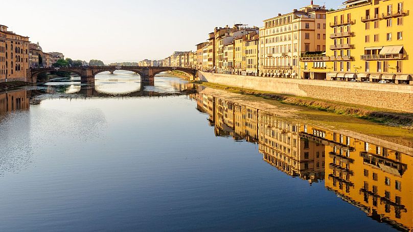 Historical buildings reflecting in the water of the River Arno, Florence