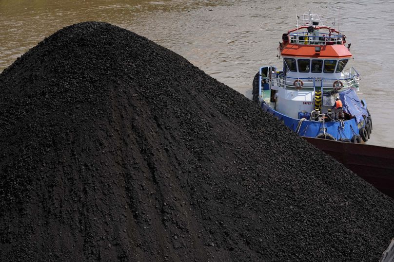 A tugboat pushes a barge carrying coal on Mahakam river in Samarinda, East Kalimantan, Indonesia.