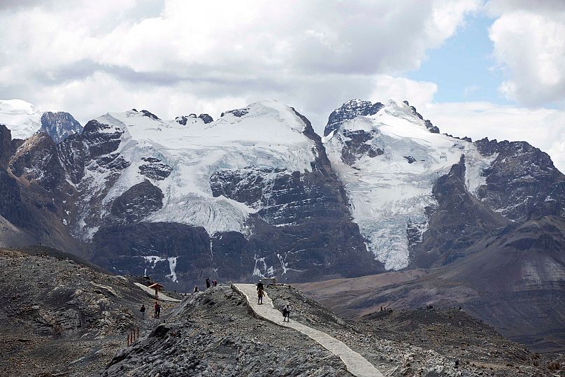 ourists walk in front of the Tuco glacier in Huascaran National Park.