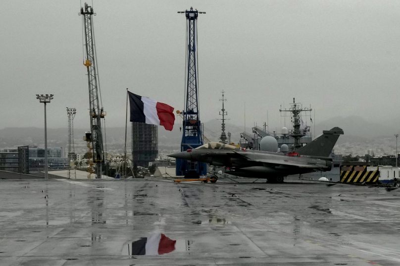 Un caccia Rafale accanto a una bandiera francese, sulla portaerei a propulsione nucleare francese Charles de Gaulle, Limassol, Cipro, 1 marzo 2022