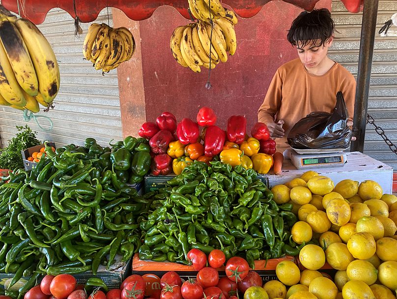 Un niño palestino se encuentra frente a un puesto de frutas y verduras en la ciudad de Deir al-Balah el 7 de marzo