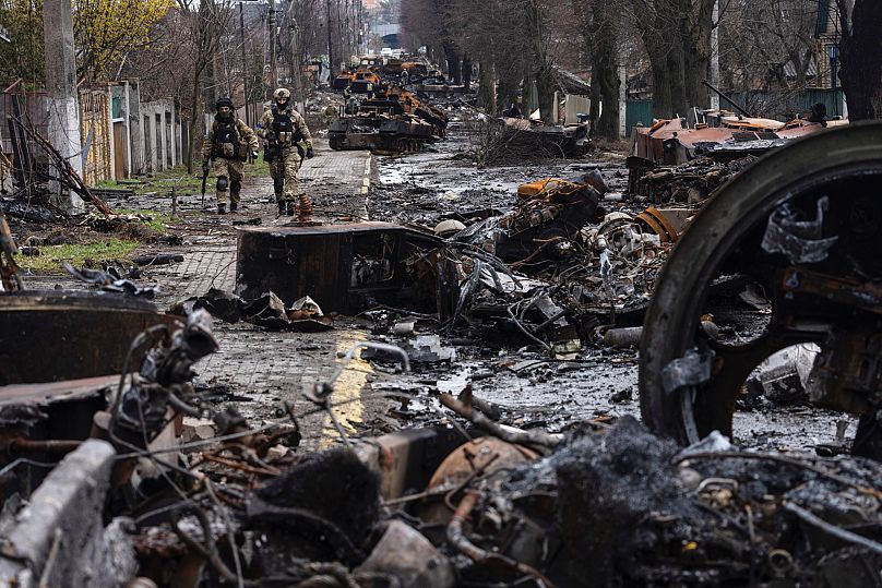  Des soldats marchent au milieu de chars russes détruits à Boutcha, dans la banlieue de Kyiv, en Ukraine, le 3 avril 2022.