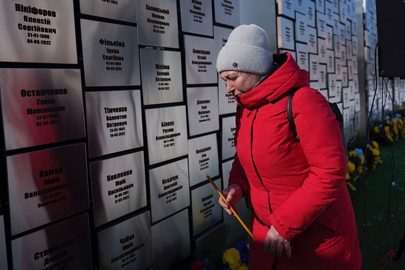 Une femme devant le mémorial de Boutcha