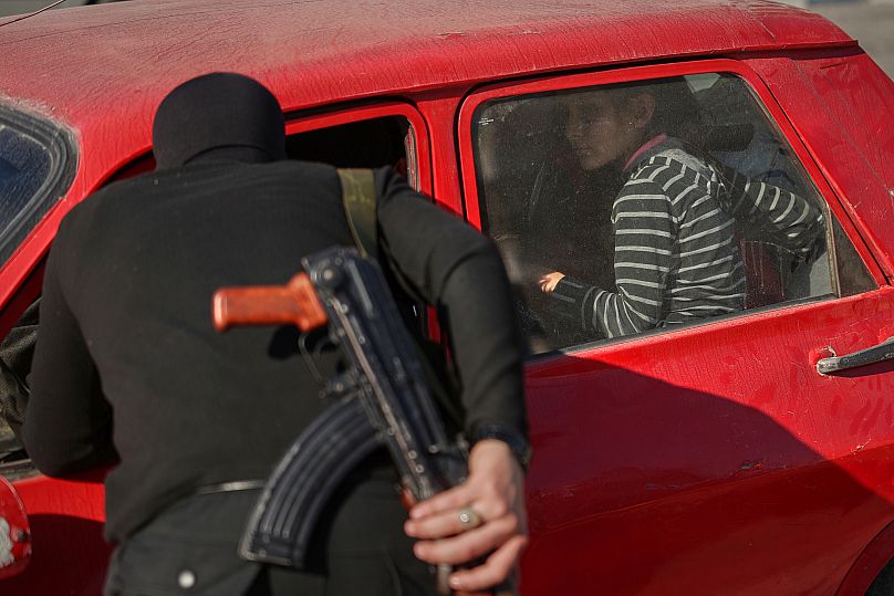 Syrian security forces inspect vehicles at a checkpoint in Latakia, 12 March 2025