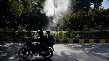 A motorcyclist drives past sprinklers that spray water in hopes of settling dust and calming air pollution in New Delhi, Feb. 12, 2025. A motorcyclist drives past sprinklers that spray water in hopes of settling dust and calming air pollution in New Delhi, Feb. 12, 2025.