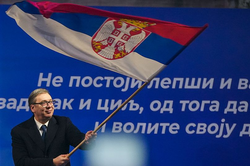 Prezydent Serbii Aleksandar Vucic macha serbską flagą po wiecu w mieście Jagodina