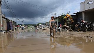 FOTO DE ARCHIVO - Una mujer camina por una calle inundada en Esmeraldas, Ecuador, el lunes 5 de junio de 2023.