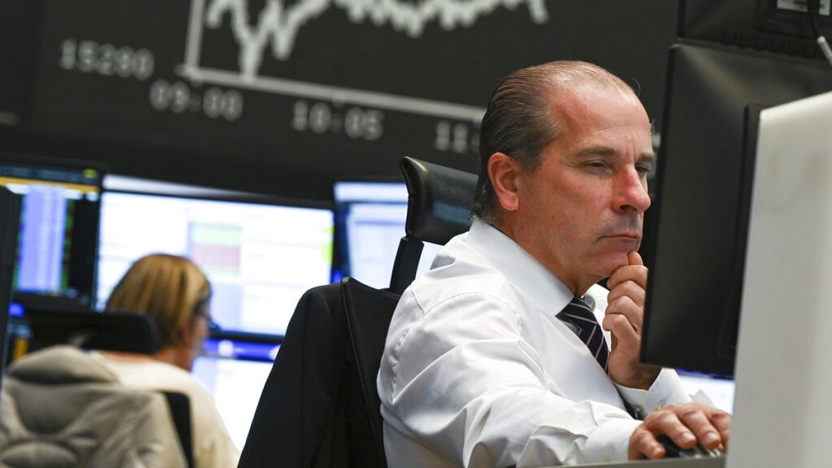 A stock trader looks at his monitors in the trading room of the Frankfurt Stock Exchange in Frankfurt, Germany, Friday, Nov. 26, 2021.