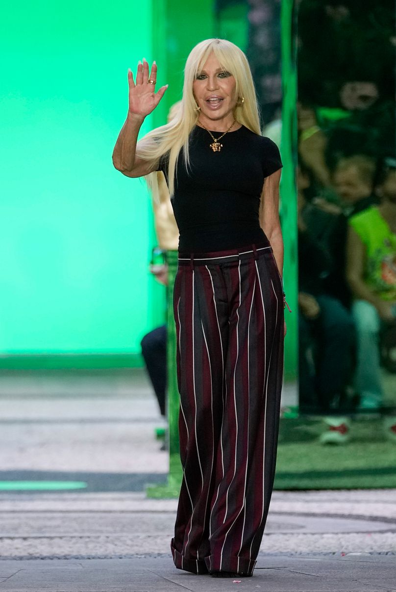 La diseñadora Donatella Versace recibe aplausos al final de la colección masculina Primavera Verano 2023 de Versace presentada en Milán, Italia - 18 de junio de 2022