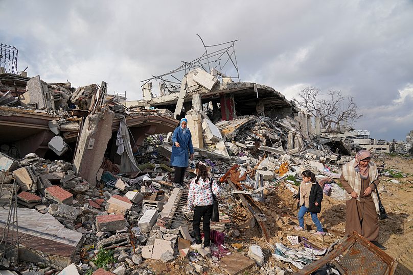 Una familia contempla su casa en ruinas el pasado 24 de febrero.