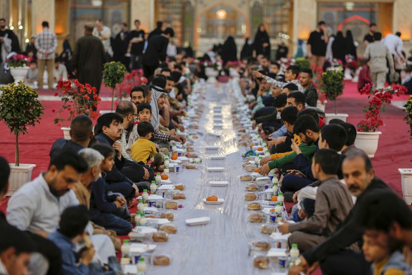 مسلمون يفطرون خلال شهر رمضان في ضريح الإمام علي في النجف، العراق، يوم الخميس، 28 آذار/مارس 2024.