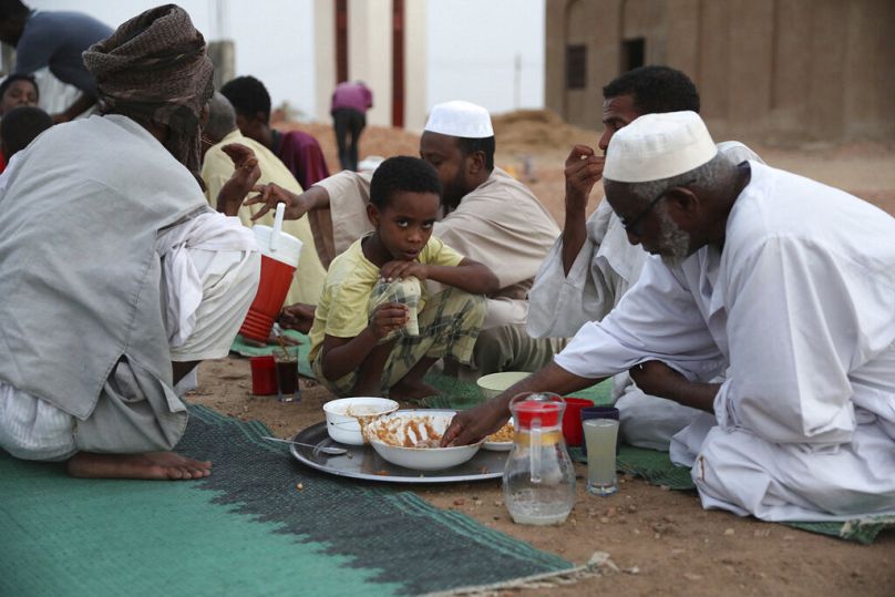 مسلمون يتناولون الطعام خلال شهر رمضان في قرية النوبة، جنوب العاصمة السودانية الخرطوم، الخميس 29 أبريل 2021.