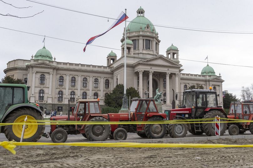 Tractors brought in by supporters of the Serbian president Aleksandar Vucic are parked on the street in front of the parliament building, in Belgrade, Serbia, Friday, March 14