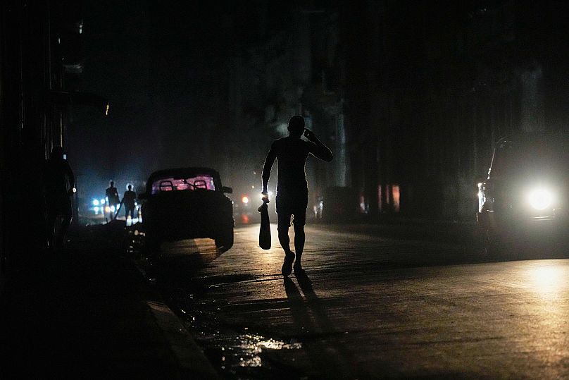 Местный житель идет по улице во время всеобщего отключения электроэнергии в Гаване, Куба, пятница, 14 марта 2025 года.
