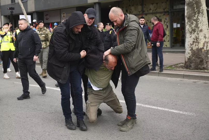 Ein Mann, der behauptet haben soll, eine Bombe bei sich zu tragen, wird bei der Kundgebung in Belgrad von Polizisten in Zivil festgenommen. 15. März 2025