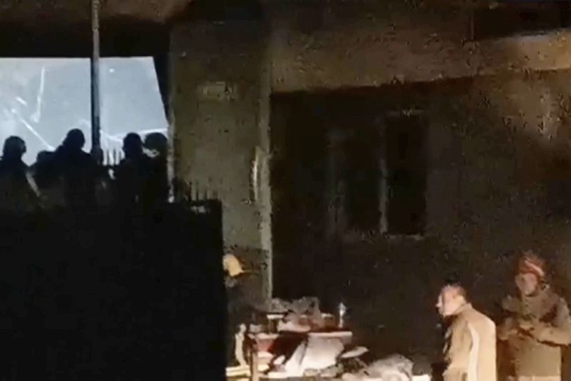 Des secouristes se tiennent devant un club après qu'un gigantesque incendie se soit déclaré tôt dimanche à Kočani, en Macédoine du Nord, le 16 mars 2025. 