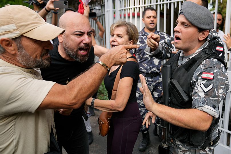 شرطي لبناني يمنع متظاهرين من دخول مبنى المحكمة أثناء احتجاجهم ضد حاكم مصرف لبنان المركزي السابق رياض سلامة، في بيروت، لبنان، الاثنين 9 سبتمبر/أيلول 2024