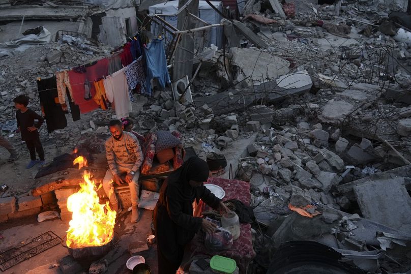 Des membres d'une famille cuisinent devant leur maison détruite par l'armée israélienne à Jabaliya, dans la bande de Gaza, le lundi 17 mars 2025.