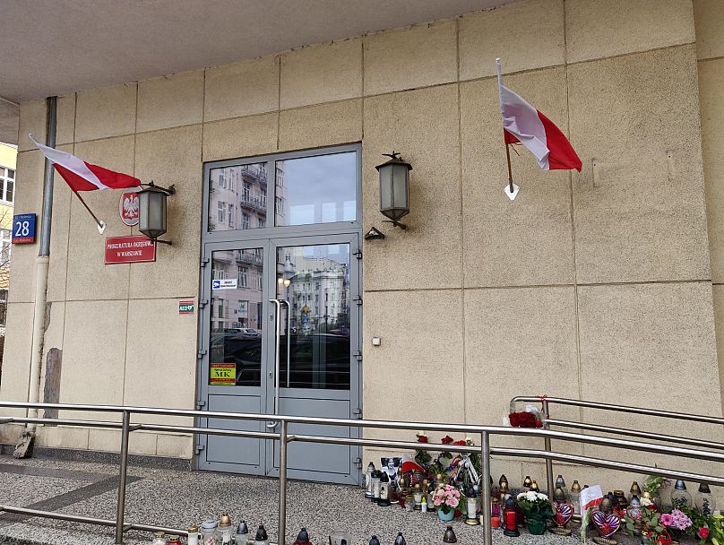 Wejście do Prokuratury Okręgowej w Warszawie z ułożonymi zniczami i kwiatami, 18 marca 2025r.