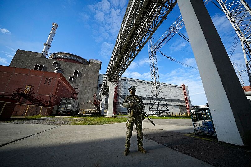 Um militar russo vigia uma área da central nuclear de Zaporizhzhia, em território sob controlo militar russo.