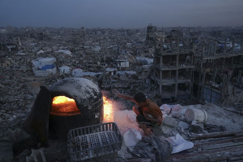 فلسطيني يطبخ على سطح منزله المدمر جراء الهجوم الجوي والبري للجيش الإسرائيلي في جباليا، قطاع غزة، يوم الاثنين، 17 مارس/آذار 2025. 