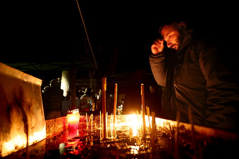 Un uomo accende candele durante una veglia a Kočani, 18 marzo 2025