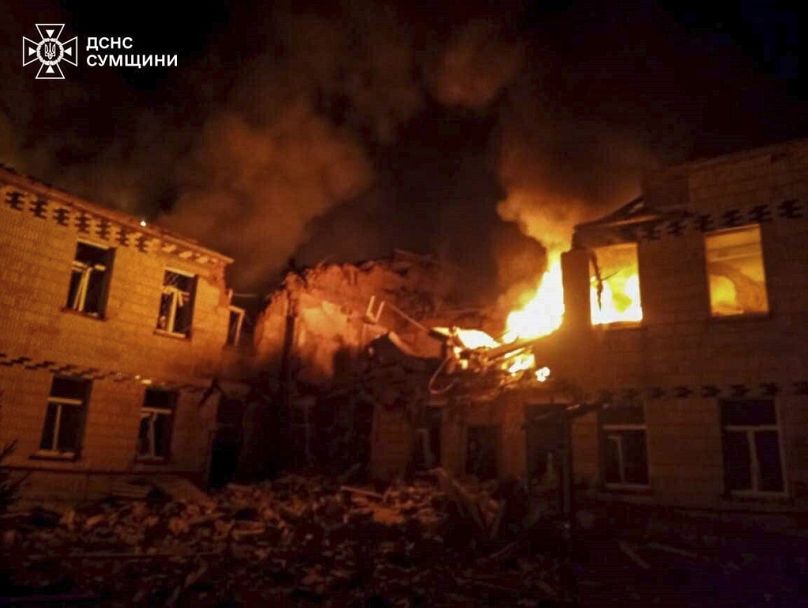 Photo fournie par les services d'urgence ukrainiens le 19 mars 2025. Des flammes et de la fumée engloutissent le bâtiment après une attaque russe à Krasnopillia, en Ukraine. 