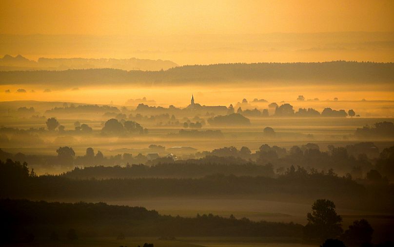 A church tower rises from the ground fog in Offingen as a heatwave spreads across Europe, 7 August, 2020