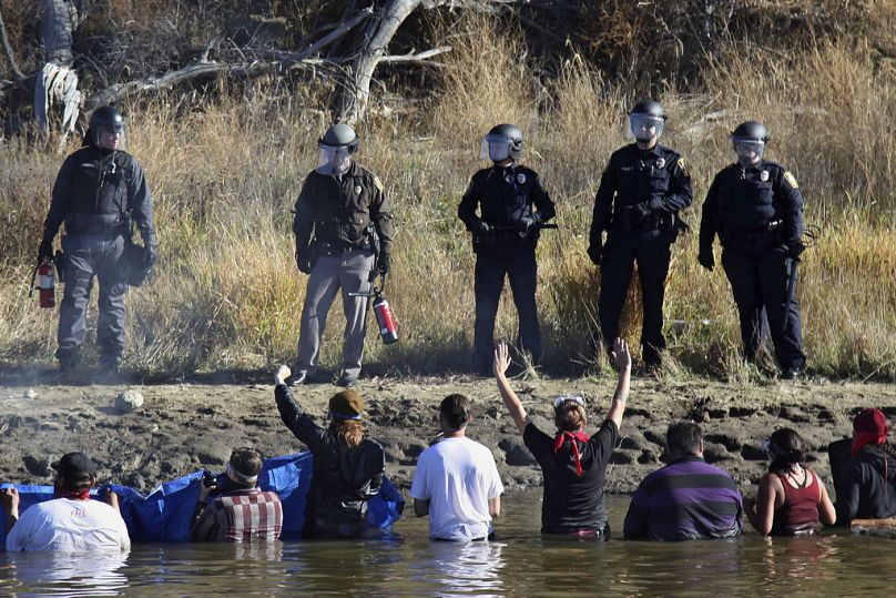 Protestors demonstrating against the expansion of the Dakota Access Pipeline wade in cold creek waters confronting local police, near Cannon Ball, North Dakota in 2016.