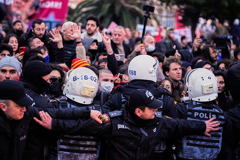 Agentes da polícia bloqueiam manifestantes durante um protesto contra a detenção do presidente da câmara de Istambul, Ekrem İmamoğlu.