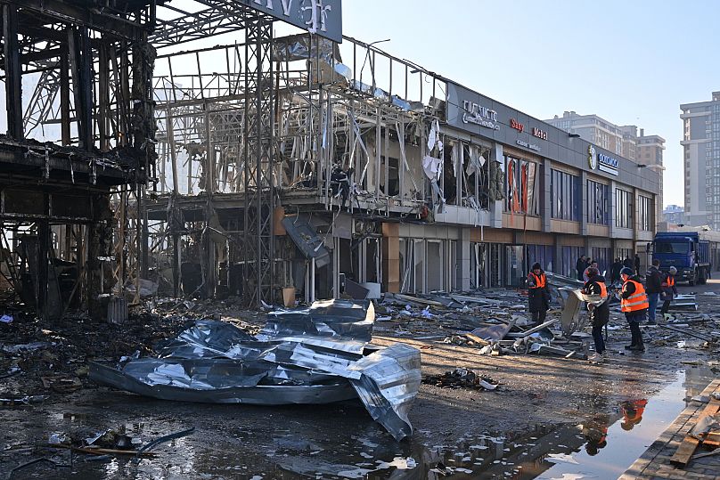 Municipal workers clean up after Russian drones hit shops during the night attack in Odesa, 21 March, 2025