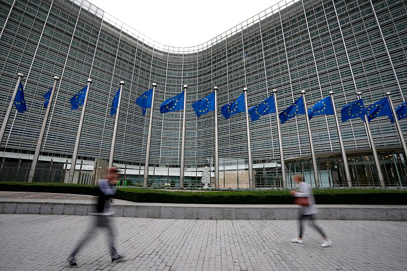 European Union flags blow in the wind as pedestrians walk by EU Commission headquarters in Brussels, 20 September, 2023