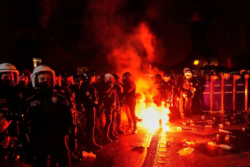 Protesters throw a flare towards anti-riot police during clashes at a rally in Istanbul, 21 March, 2025