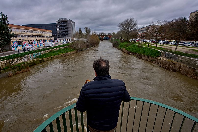 Mężczyzna obserwuje rzekę Manzanares przepływającą przez Madryt po ulewnych deszczach, Hiszpania, piątek, 21 marca 2025 r.