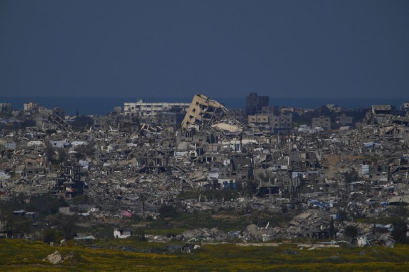 Des bâtiments détruits lors des opérations terrestres et aériennes israéliennes dans le nord de la bande de Gaza, vus depuis le sud d'Israël, dimanche 23 mars 2025.