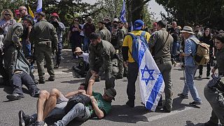 Des policiers israéliens dispersent des manifestants qui bloquent la route menant au parlement avant un vote clé sur le budget de l'État à Jérusalem, mardi 25 mars 2025.
