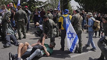 Des policiers israéliens dispersent des manifestants qui bloquent la route menant au parlement avant un vote clé sur le budget de l'État à Jérusalem, mardi 25 mars 2025. Des policiers israéliens dispersent des manifestants qui bloquent la route menant au parlement avant un vote clé sur le budget de l'État à Jérusalem, mardi 25 mars 2025.